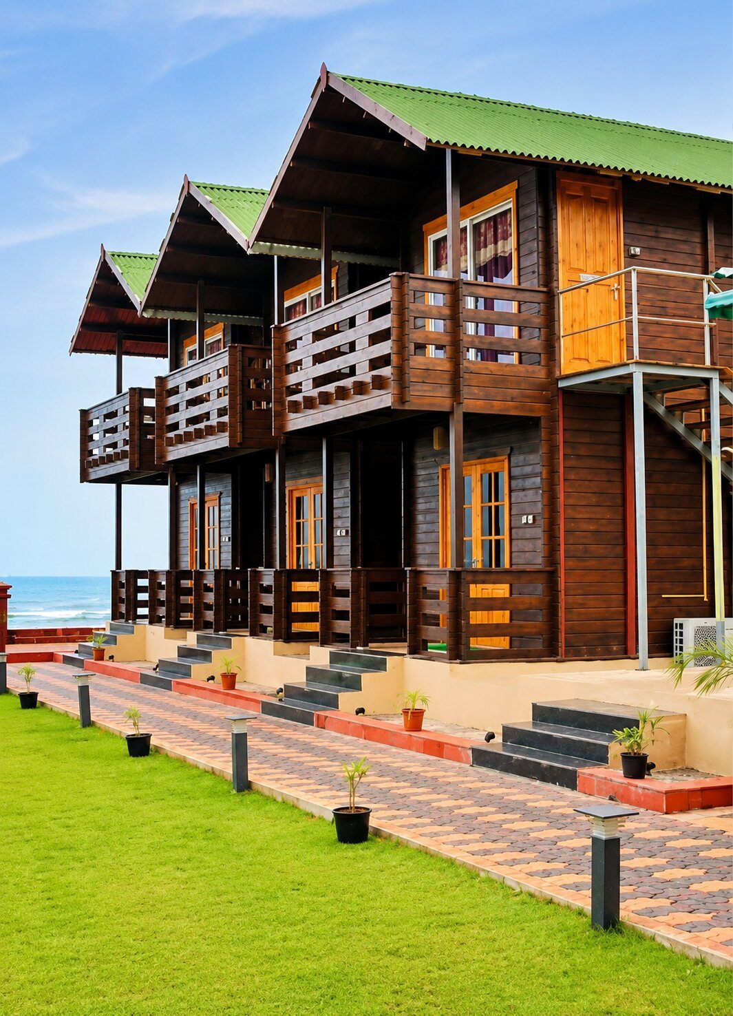Two-storey wooden cottage suites with private balconies along a landscaped waterfront pathway