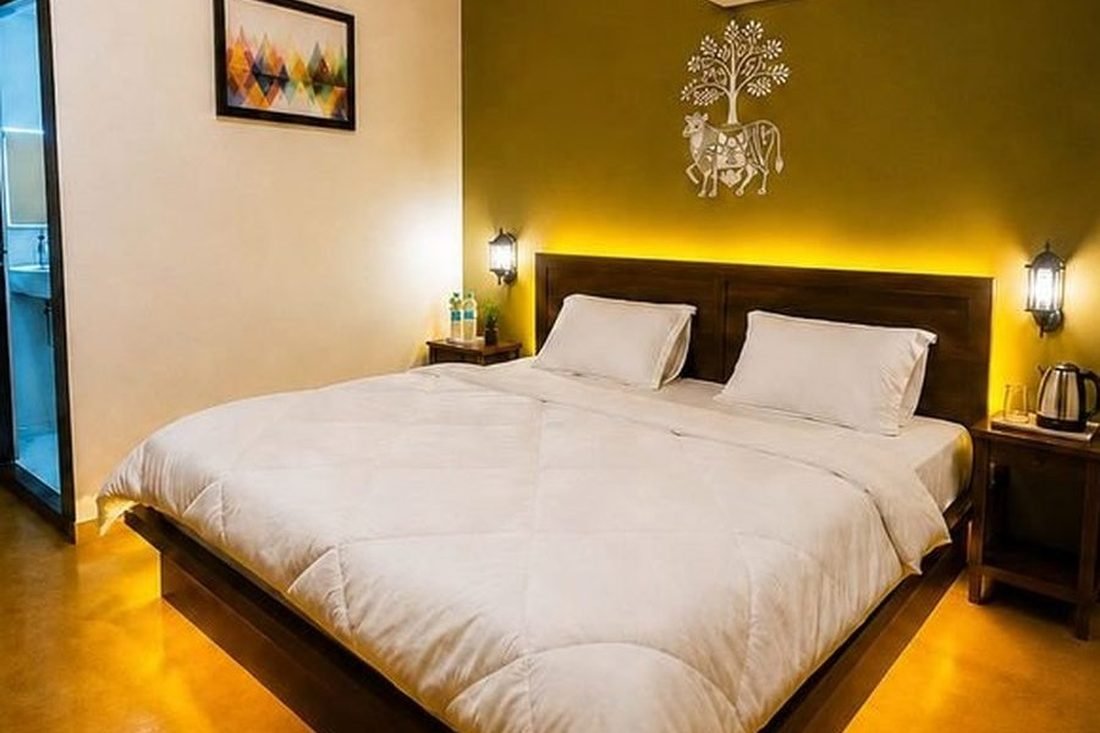 Luxury guest room interior with wooden headboard and Warli art wall