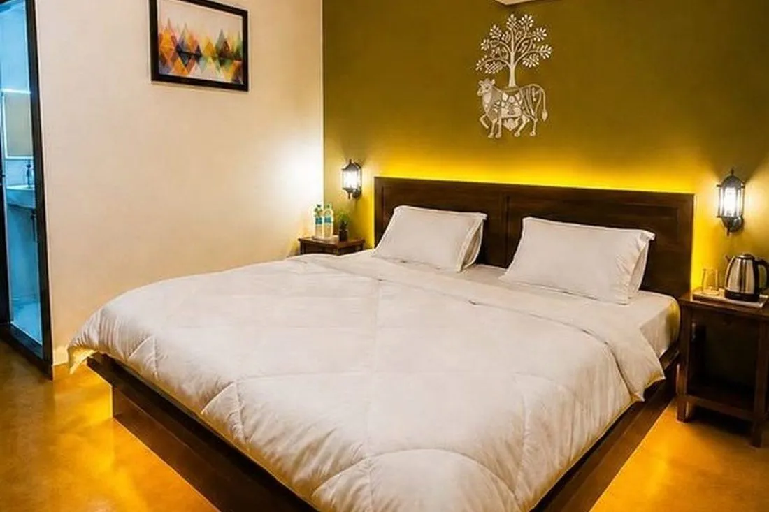 Luxury guest room interior with wooden headboard and Warli art wall